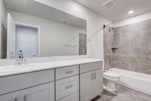 full bathroom with toilet, tiled shower / bath, and vanity