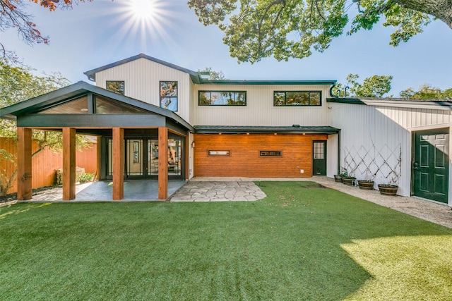 rear view of property featuring a patio area and a lawn