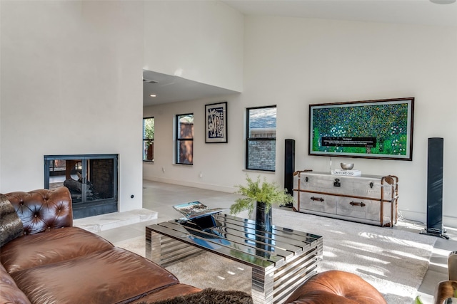 living room featuring light colored carpet, a tile fireplace, and a towering ceiling