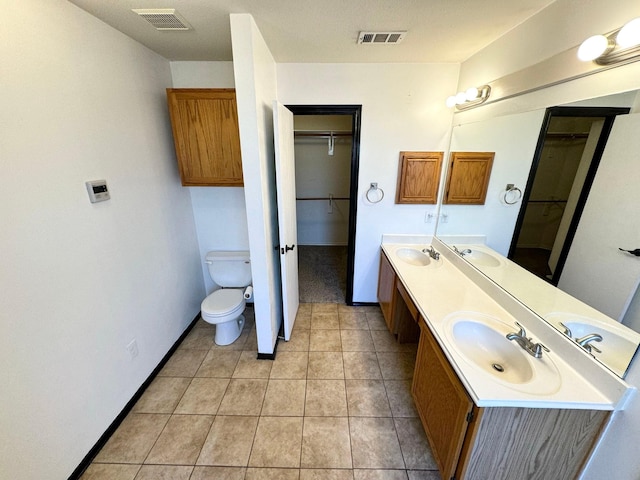 bathroom with toilet, tile patterned flooring, and vanity