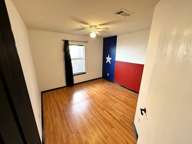 unfurnished room with ceiling fan and hardwood / wood-style flooring