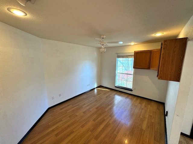 unfurnished room with a textured ceiling, ceiling fan, and light hardwood / wood-style floors