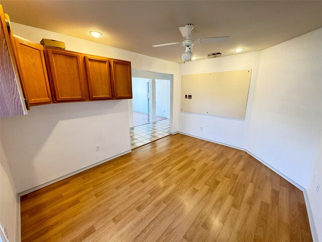 spare room with light wood-type flooring and ceiling fan