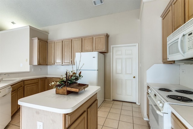 kitchen featuring sink, light tile patterned floors, white appliances, and a center island