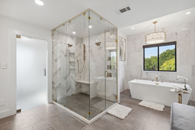 bathroom featuring tile walls and independent shower and bath