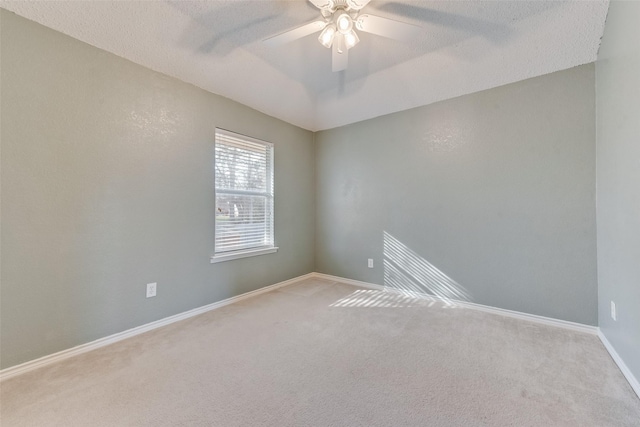 spare room with vaulted ceiling, light carpet, a textured ceiling, and ceiling fan