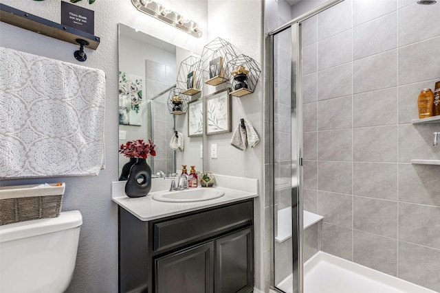 bathroom featuring toilet, an enclosed shower, and vanity