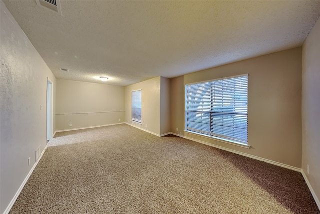 carpeted empty room with a textured ceiling