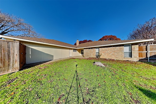 rear view of property with a yard