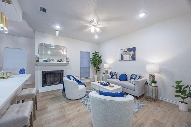 living room with ceiling fan and light hardwood / wood-style flooring