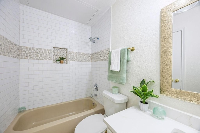 full bathroom with tiled shower / bath, vanity, and toilet