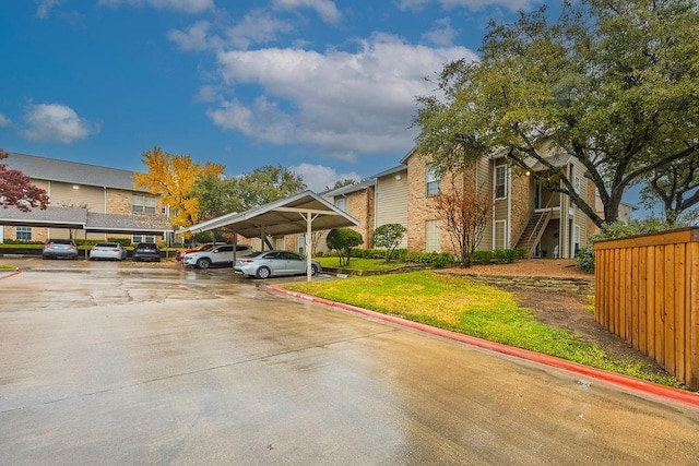 view of parking / parking lot featuring a carport and a lawn