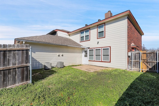 back of house with cooling unit, a yard, and a patio