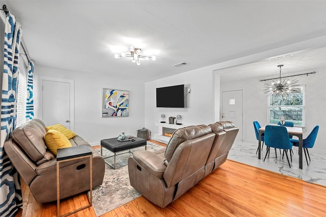 living room featuring a notable chandelier and light hardwood / wood-style floors