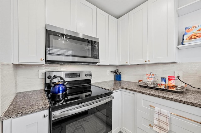 kitchen featuring stainless steel appliances, white cabinets, and dark stone countertops