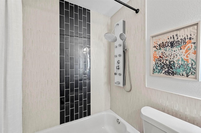 bathroom with tiled shower / bath combo and toilet