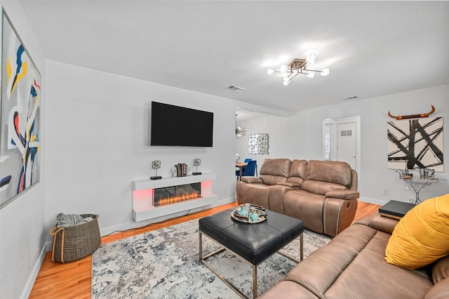 living room with an inviting chandelier and wood-type flooring