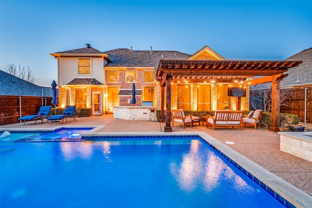 pool at dusk featuring a patio, a pergola, and an outdoor living space