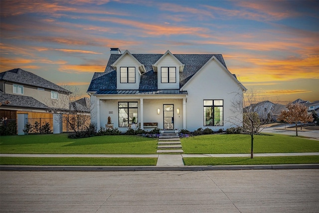 view of front of home with a porch and a lawn