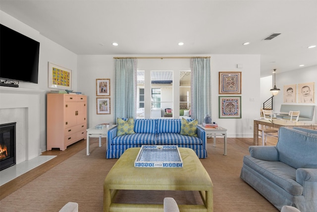 living room featuring light hardwood / wood-style floors and a high end fireplace