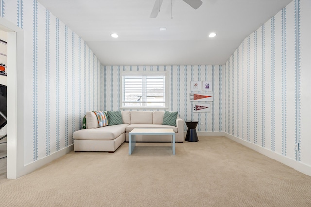 living area featuring light colored carpet and ceiling fan