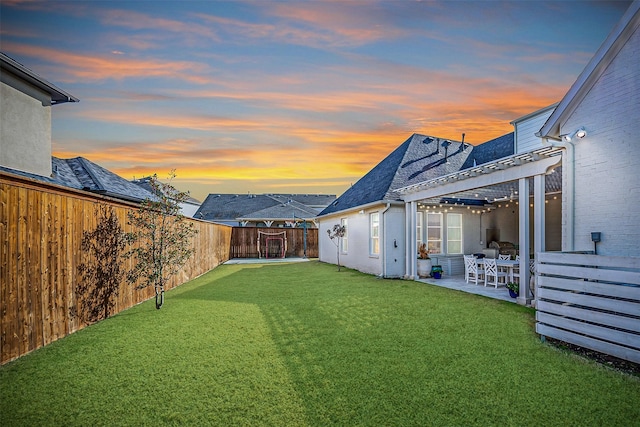 yard at dusk featuring a patio and a pergola