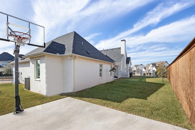 view of side of property featuring a patio area, cooling unit, and a yard