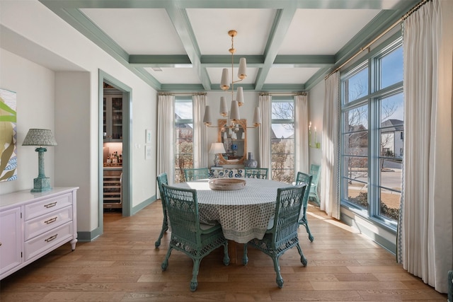 dining space featuring light hardwood / wood-style flooring, beam ceiling, and coffered ceiling