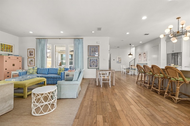 living room with a notable chandelier and light hardwood / wood-style flooring