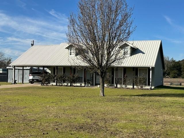 view of front facade with a front yard and a carport