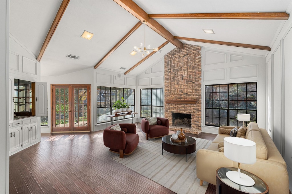 living room with a brick fireplace, high vaulted ceiling, a notable chandelier, and beamed ceiling