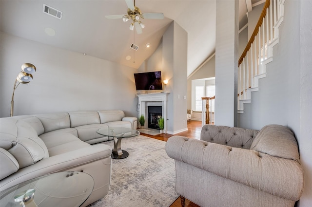 living room featuring ceiling fan, light wood-type flooring, and high vaulted ceiling