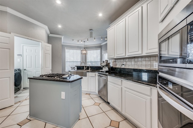 kitchen featuring appliances with stainless steel finishes, white cabinets, and washer / clothes dryer