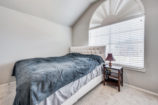 carpeted bedroom with lofted ceiling