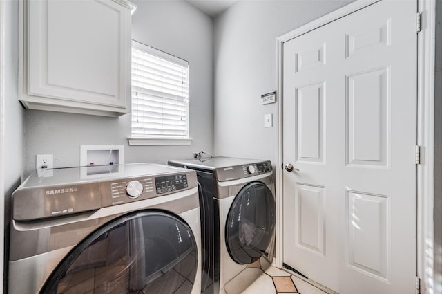 washroom featuring separate washer and dryer and cabinets