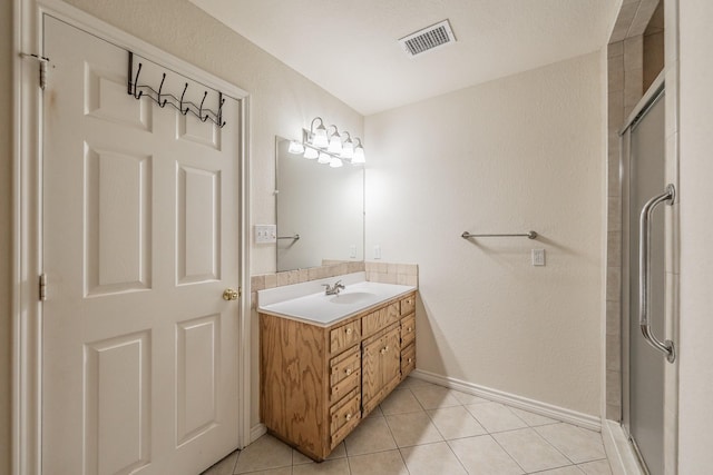 bathroom featuring a shower with shower door, tile patterned floors, and vanity