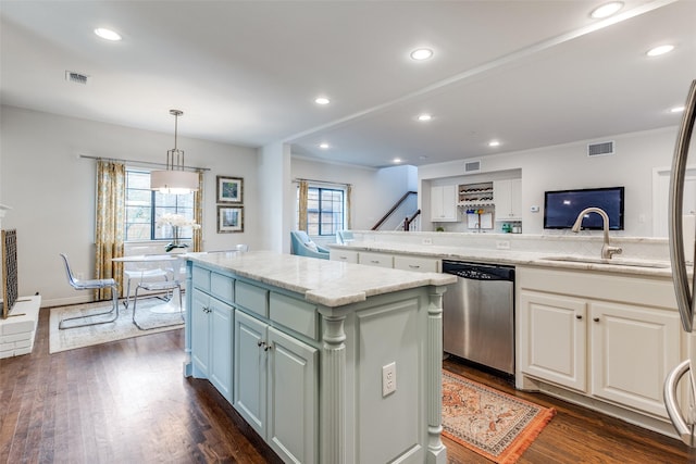 kitchen featuring sink, stainless steel dishwasher, a kitchen island, pendant lighting, and dark wood-type flooring