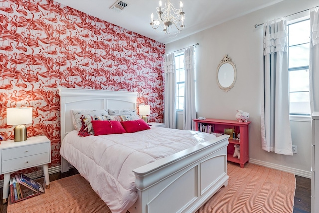 bedroom with light wood-type flooring and a notable chandelier