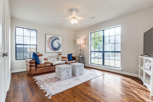 living room with dark hardwood / wood-style flooring and ceiling fan