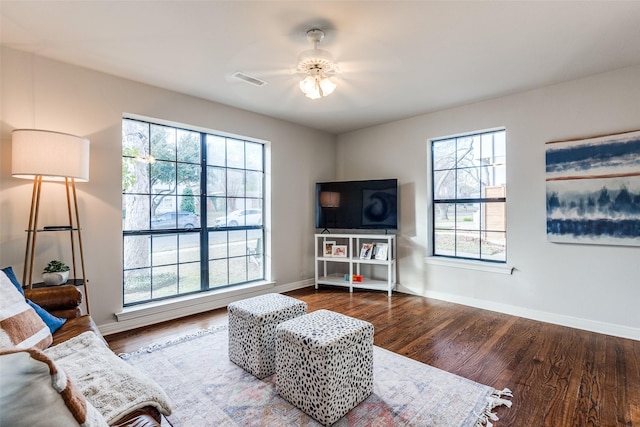 living room featuring ceiling fan, a healthy amount of sunlight, and dark hardwood / wood-style floors