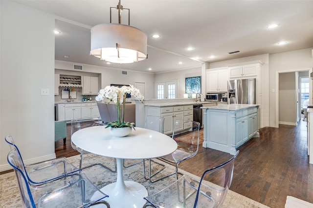 dining space with sink, plenty of natural light, and dark hardwood / wood-style floors