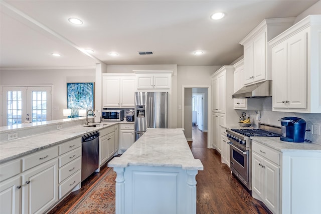 kitchen featuring dark wood-type flooring, tasteful backsplash, white cabinets, appliances with stainless steel finishes, and sink