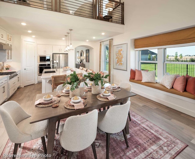 dining space with a high ceiling and light hardwood / wood-style floors