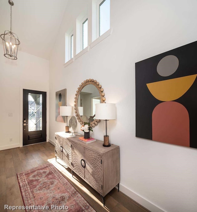 entryway featuring a towering ceiling, a chandelier, and dark hardwood / wood-style floors