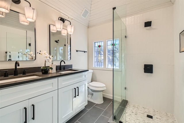 bathroom featuring toilet, tile patterned flooring, a tile shower, crown molding, and vanity