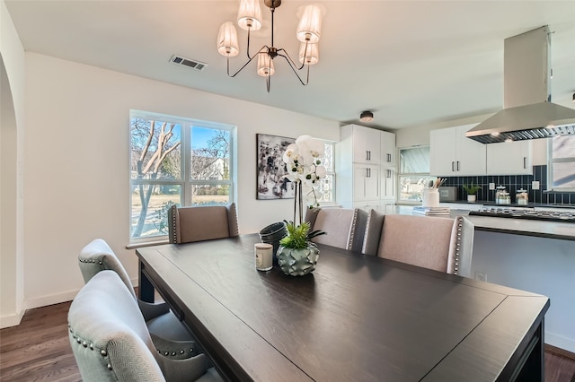 dining area featuring an inviting chandelier and dark hardwood / wood-style floors