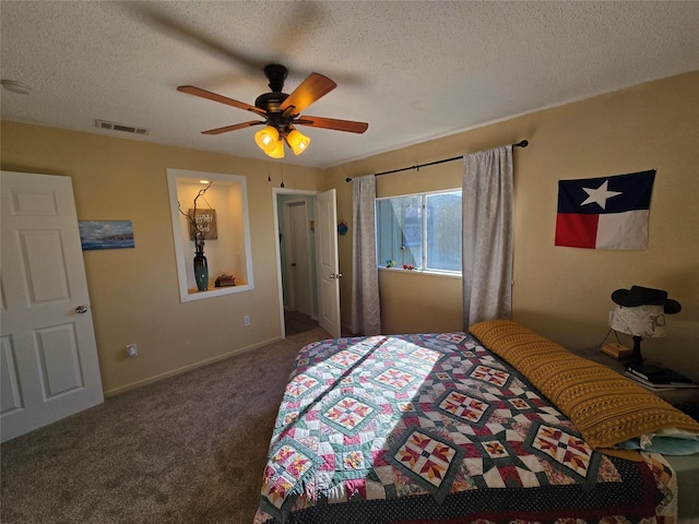 carpeted bedroom with a textured ceiling and ceiling fan