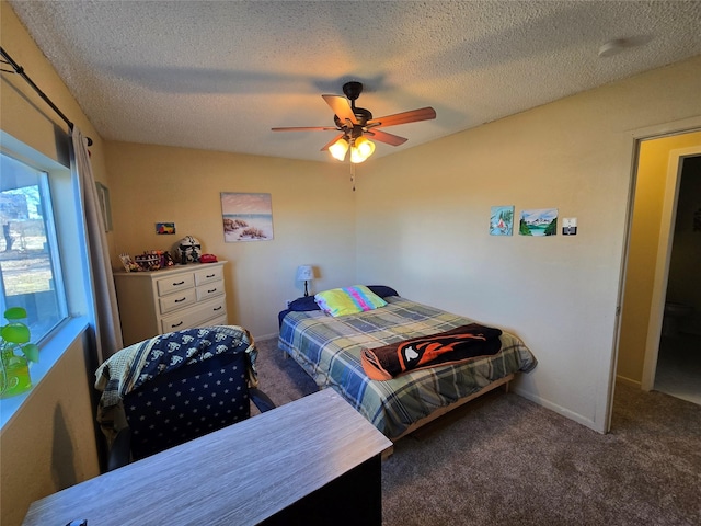 bedroom featuring a textured ceiling, ceiling fan, and dark colored carpet