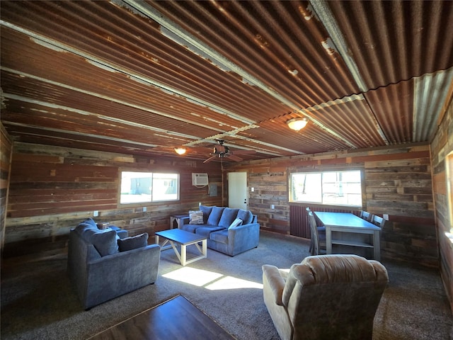 carpeted living room featuring ceiling fan and wooden walls