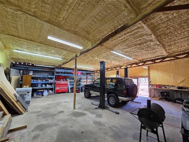 garage featuring a workshop area and wooden walls